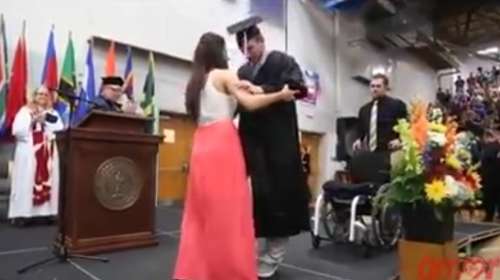 Discapacitado es ayudado por su novia para recibir el titulo en la ceremonia de graduacion